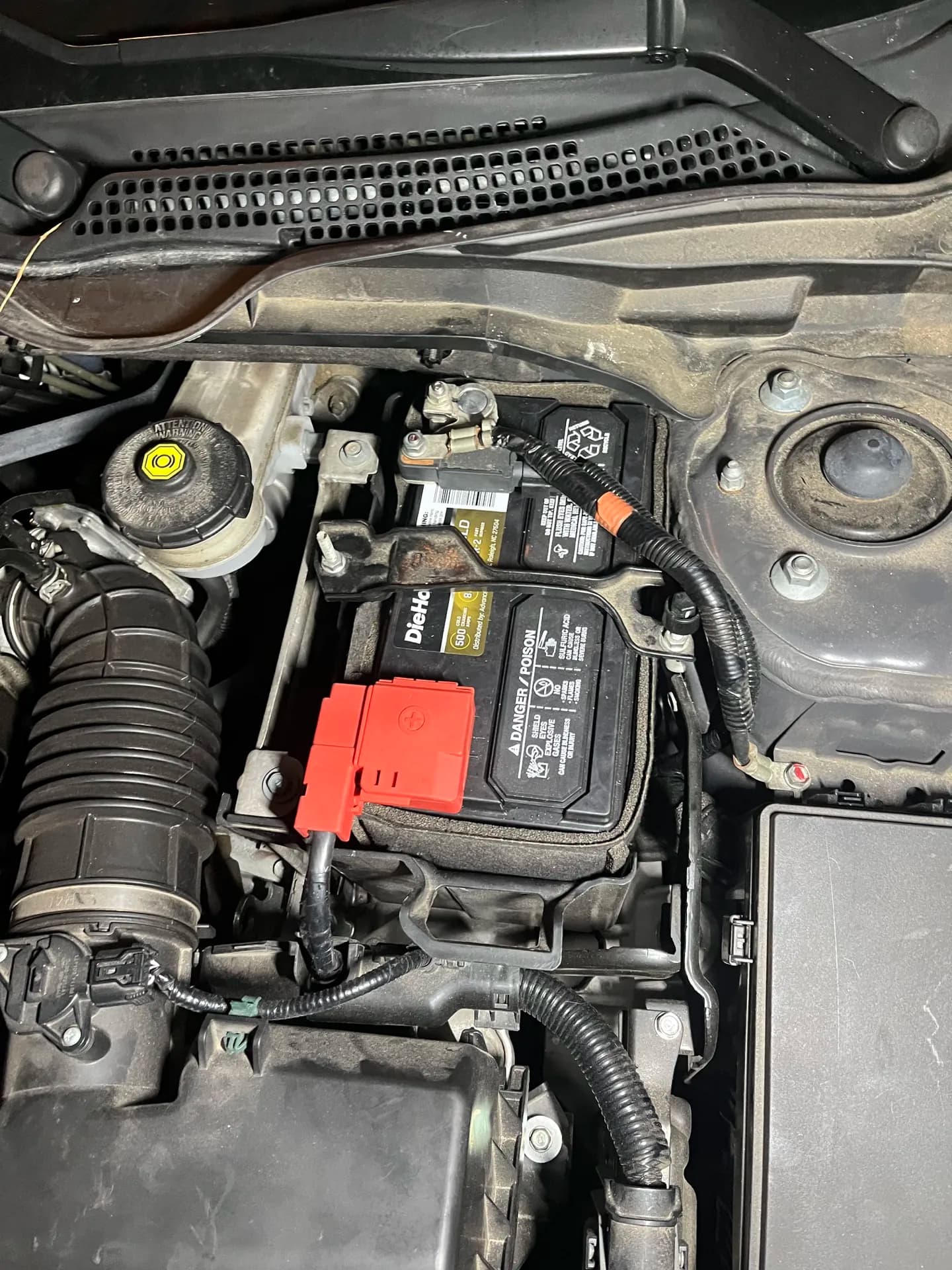 Vehicle battery and cable connections inspected under the hood